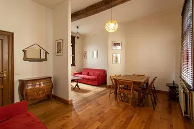 a living room with a red couch and a table at Coeur Saint-Jacques in Brussels