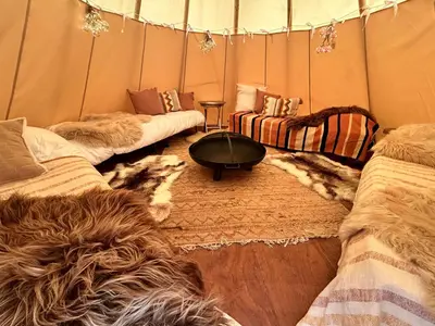a room with three couches and a table in a tent at Comfort Tipi Marie, Tipi Bo Deluxe & tent Nicolaï - 'Glamping in stijl' in Lembeke