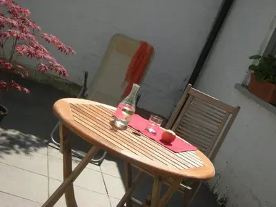 a wooden table with a bottle and two glasses on it at Au Bout du Jardin in Waterloo