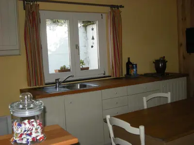 a kitchen with a sink and a window and a table at Au Bout du Jardin in Waterloo