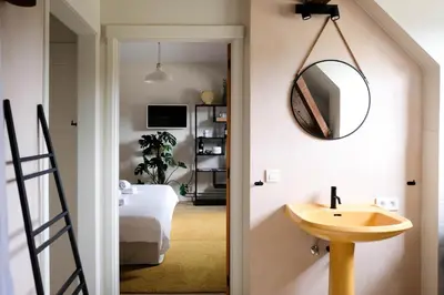 a bathroom with a sink and a mirror on the wall at Villa Parkbos in De Pinte