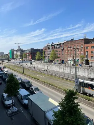 a city street with cars parked in a parking lot at Cosy appartement with canal view in Brussels