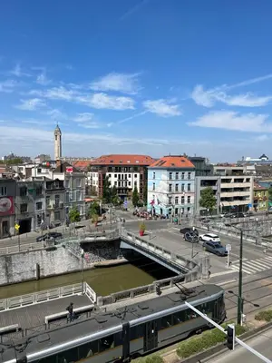 a city with a bridge over a river and buildings at Cosy appartement with canal view in Brussels