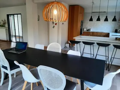 a black table with white chairs and a laptop on it at villa in Kontich