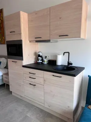 a kitchen with a sink and wooden cabinets at Whaaw Herentals in Herentals