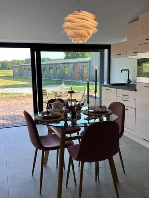 a dining room with a table and chairs and a kitchen at Whaaw Herentals in Herentals