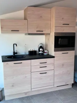 a kitchen with wooden cabinets and a black counter top at Whaaw Herentals in Herentals
