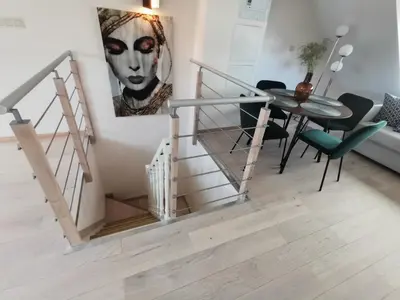 a staircase in a living room with a painting on the wall at Charming duplex on the canal Brussels in Brussels