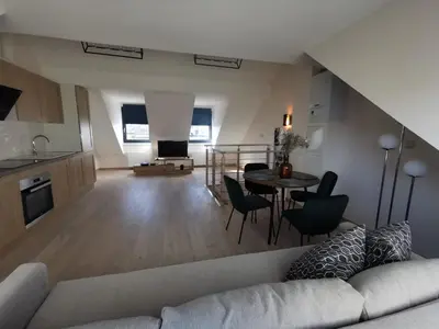 a living room with a couch and a table at Charming duplex on the canal Brussels in Brussels