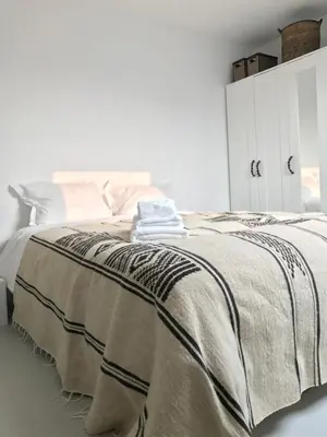 a bedroom with a bed with a blanket on it at Bright City Design House! in Antwerp