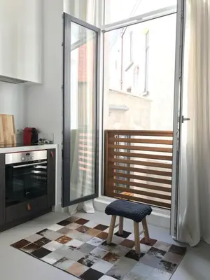 a kitchen with a stool and a large window at Bright City Design House! in Antwerp
