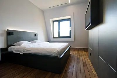 a bedroom with a bed and a flat screen tv at Sleep Well Youth Hostel in Brussels