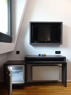 a black entertainment center with a tv on a wall at Sleep Well Youth Hostel in Brussels