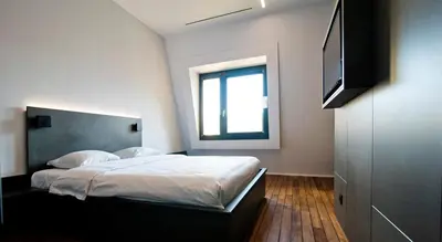 a bedroom with a bed and a flat screen tv at Sleep Well Youth Hostel in Brussels