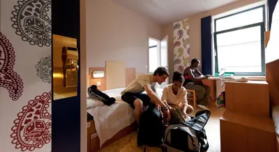 a man and woman sitting on a bed in a hotel room at Sleep Well Youth Hostel in Brussels