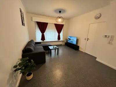 a living room with a couch and a tv at Ganha holiday house in Antwerp