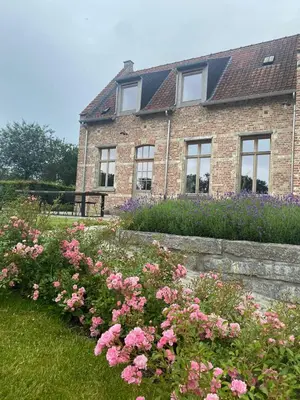 a brick house with flowers in front of it at Huis Potaerde, vakantiewoning op boerderij - luxe landhuis nabij Brussel in Merchtem
