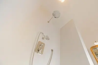 a white bathroom with a shower and a mirror at Huis Potaerde, vakantiewoning op boerderij - luxe landhuis nabij Brussel in Merchtem