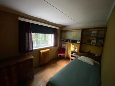 a bedroom with a bed and a desk and a window at Les Barolins in Rotselaar