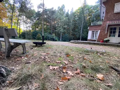 a park bench sitting in a yard next to a building at Les Barolins in Rotselaar