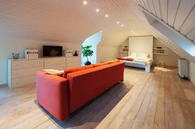 a living room with a red couch and a bed at B&B Maison Blanche in Ghent