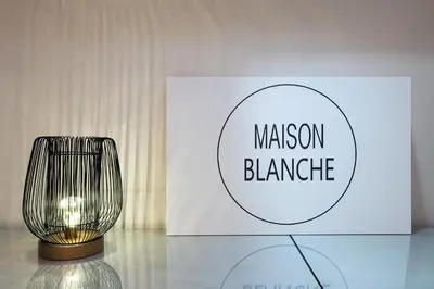 a lamp sitting on a table next to a sign at B&B Maison Blanche in Ghent