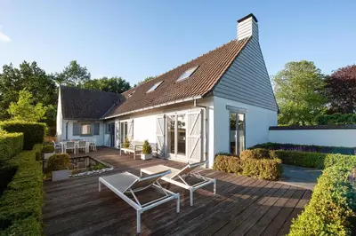 a house with a deck with chairs and a roof at B&B Maison Blanche in Ghent