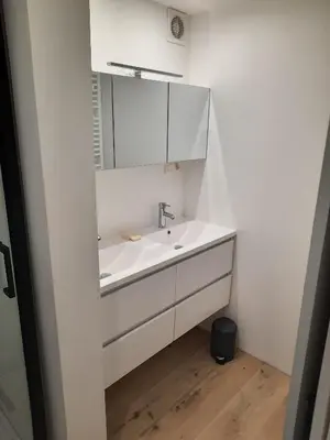 a white bathroom with a sink and a mirror at Sint Andries Duplex in Antwerp