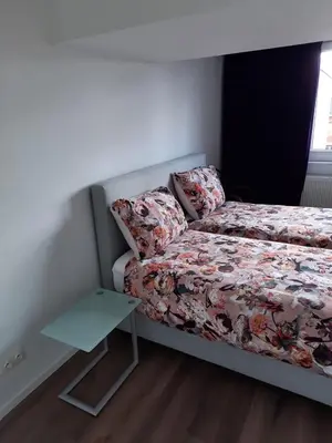 a small bedroom with a bed and a table at Sint Andries Duplex in Antwerp