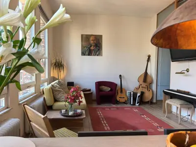 a living room with a couch and two guitars at Historical center Antwerp, all on foot in Antwerp