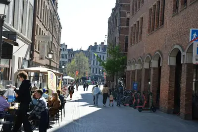 a group of people walking down a city street at Historical center Antwerp, all on foot in Antwerp
