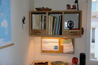 a book shelf on a wall with books on it at Historical center Antwerp, all on foot in Antwerp