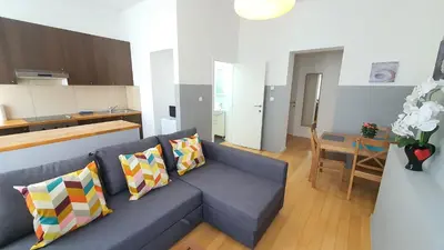 a living room with a blue couch and a kitchen at Chez Esmara et Philippe Grand-Place in Brussels