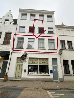 a white building with a clock on the side of it at BnB Antwerpen - CHARMANT in Antwerp