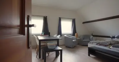 a bedroom with a bed and a desk and a bed and a table at Berkies - autonome studio in Steenokkerzeel