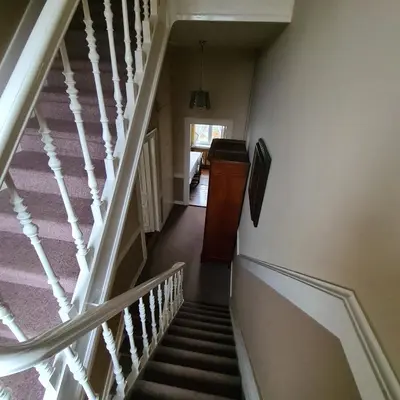 a winding staircase in a home with white railings at On our way to Antwerp, first stop in Mortsel
