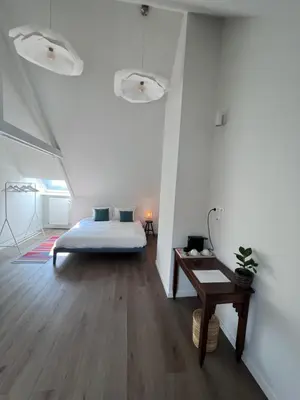a bedroom with a bed and a wooden floor at Maison Georges in Turnhout