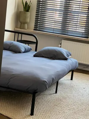 two pillows on a bed in a room with a window at Maison Georges in Turnhout