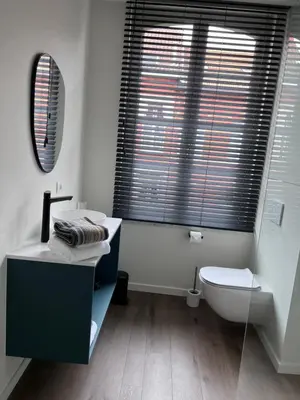 a bathroom with a sink and a toilet and a mirror at Maison Georges in Turnhout