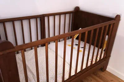 a crib in a room with a white wall at Vakantiehuis huYze-K in Zottegem