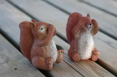 two toy squirrels sitting on a wooden bench at Glamping Zonnebloem - Back-to-Nature in Herzele