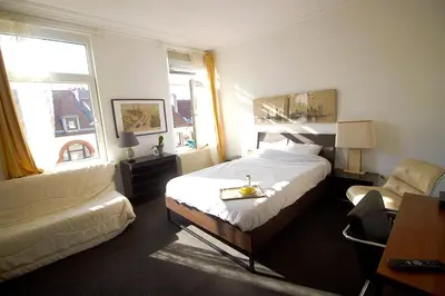 a hotel room with a bed and a chair at Handy Studio close to Zaventem airport in Brussels