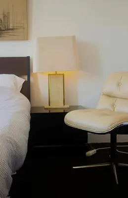 a bedroom with a bed and a chair and a lamp at Handy Studio close to Zaventem airport in Brussels