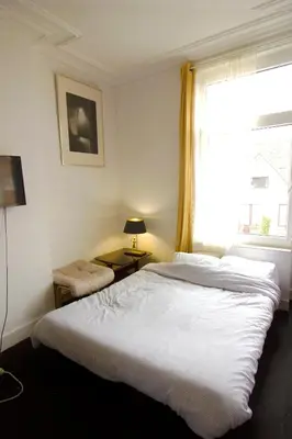 a bedroom with a large white bed and a window at Handy Studio close to Zaventem airport in Brussels
