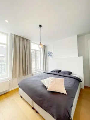 a bedroom with a large bed in a room with windows at Jacob’s Getaway in Ghent