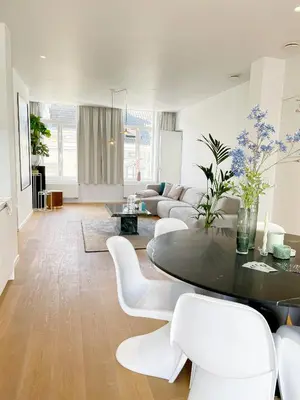 a living room with a table and white chairs at Jacob’s Getaway in Ghent