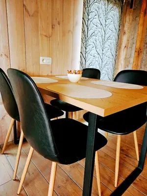 a wooden table with four black chairs around it at Le Canard - Rust aan het water in Geel