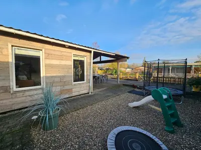a backyard with a house and a playground at Le Canard - Rust aan het water in Geel