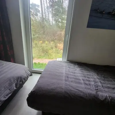 a bedroom with a bed and a large window at White Box in Gierle