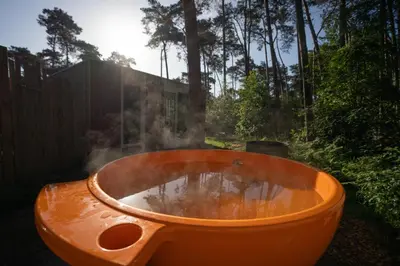 an orange bath tub sitting in a yard at White Box in Gierle